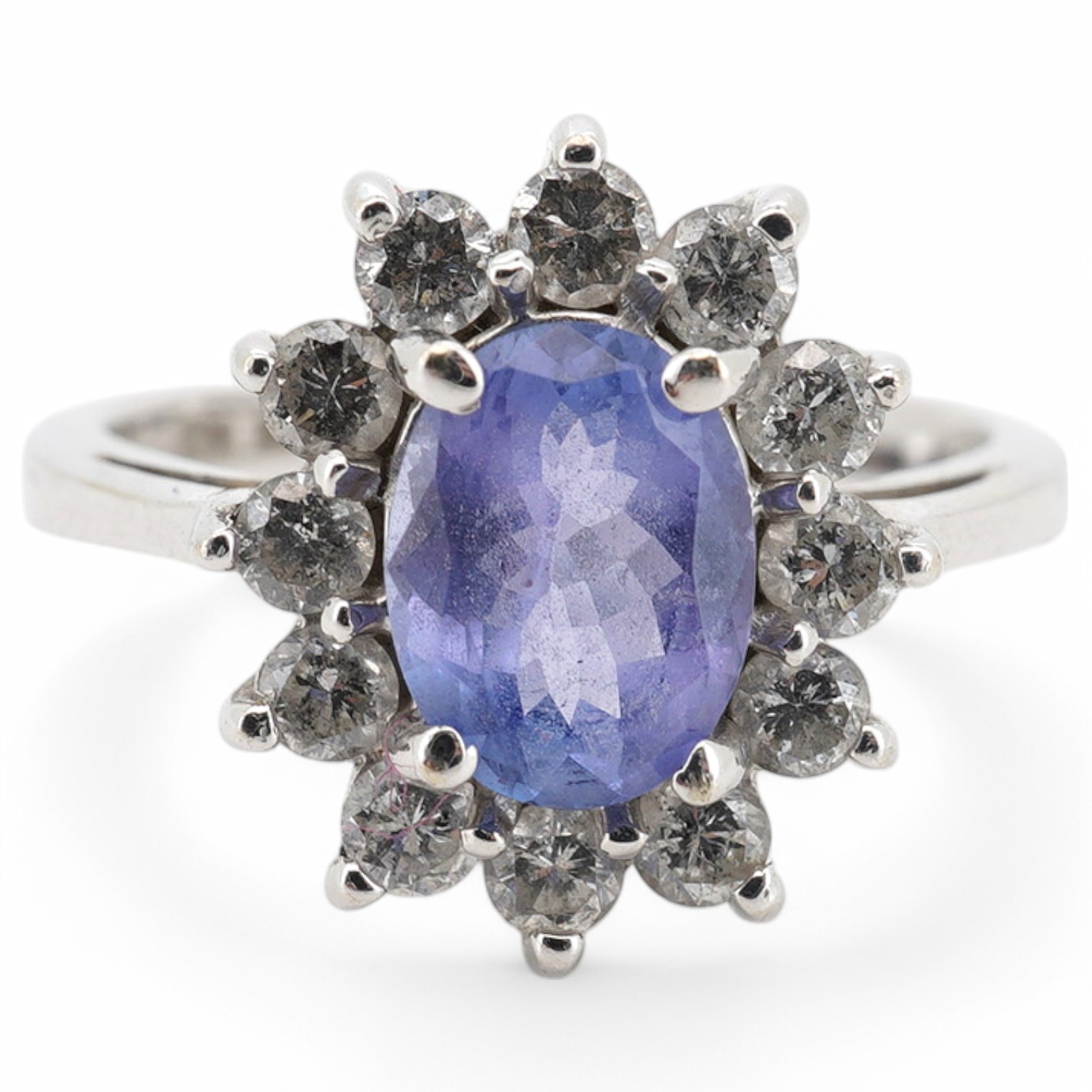 A modern 14k white metal, tanzanite and diamond set oval cluster ring, size M, gross weight 4.3 grams.